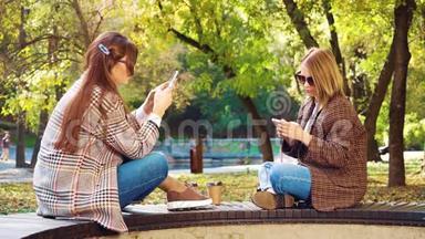 时尚女孩<strong>坐在公园里</strong>，用智能手机